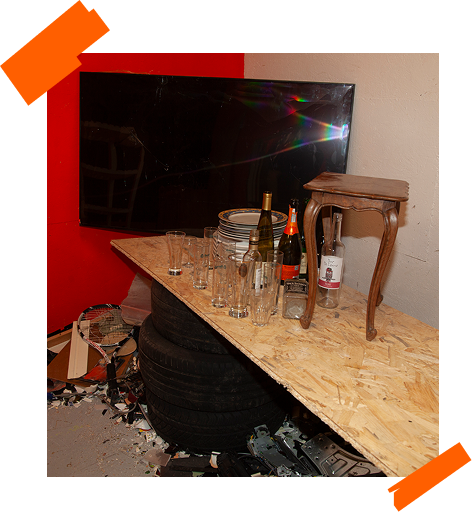 Pack Screen Breaker : grand écran avec bouteilles, verres et assiettes sur une table en OSB.